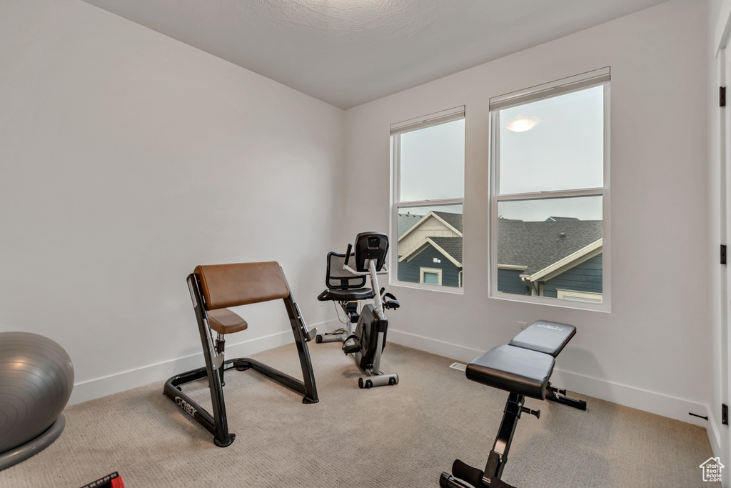 Workout room with baseboards and carpet