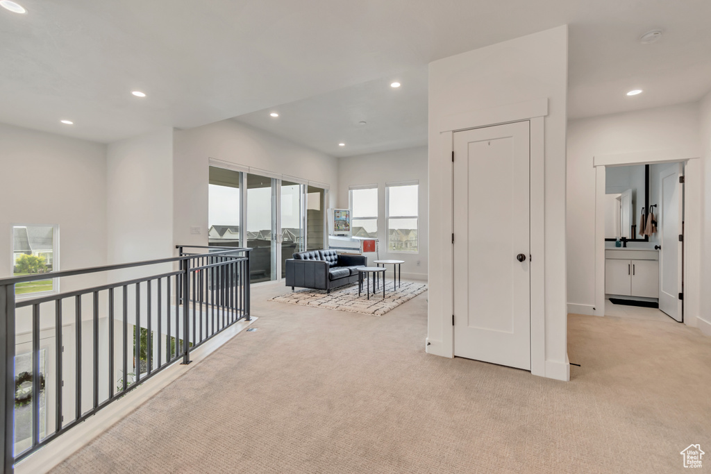 Hallway featuring light carpet and recessed lighting