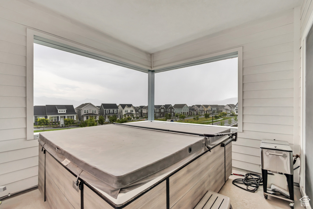 Balcony featuring a hot tub and a residential view