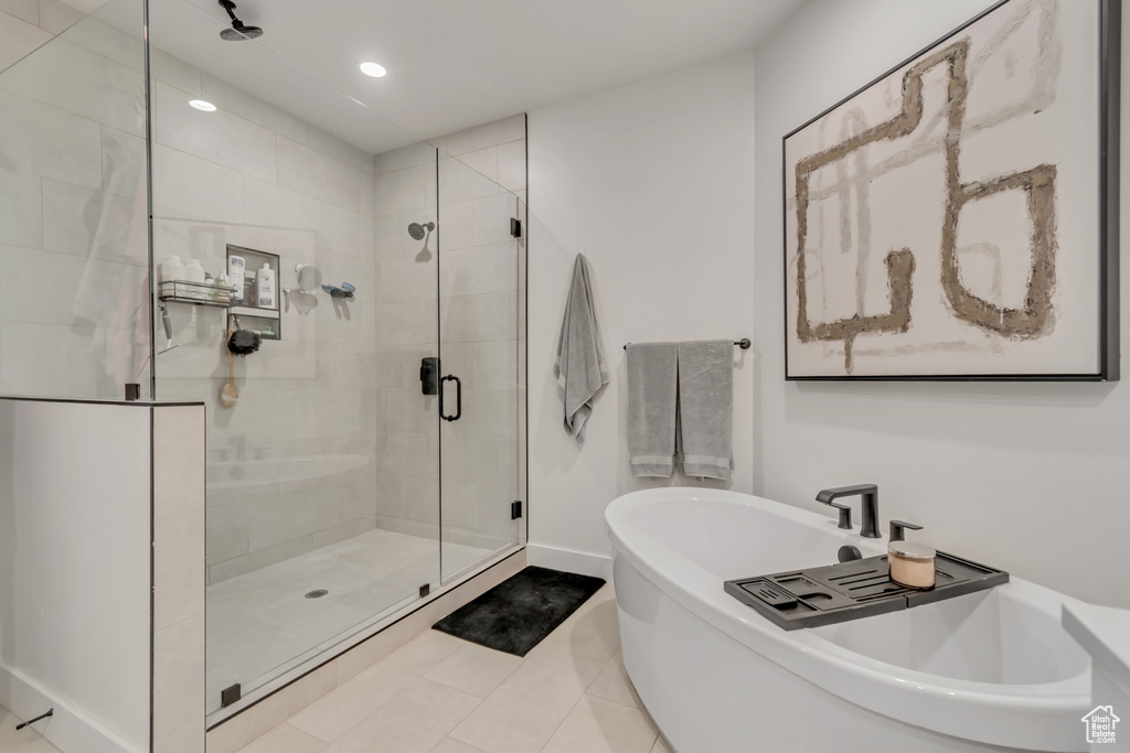 Bathroom featuring a stall shower, a freestanding tub, tile patterned flooring, and recessed lighting
