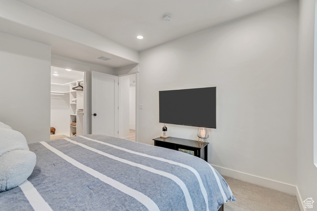 Bedroom with recessed lighting, carpet floors, and a spacious closet