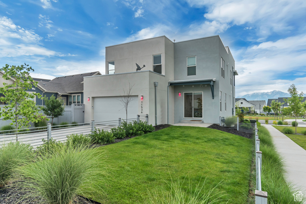Back of property with stucco siding and a garage