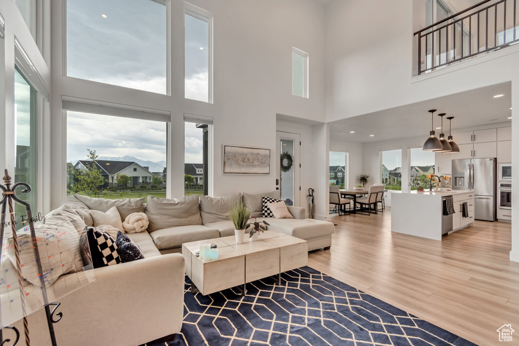 Living room featuring light wood-style floors and a high ceiling