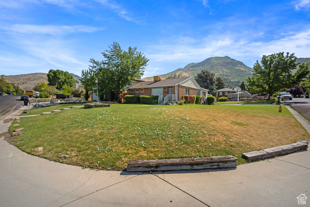 View of front facade with a mountain view and a front lawn