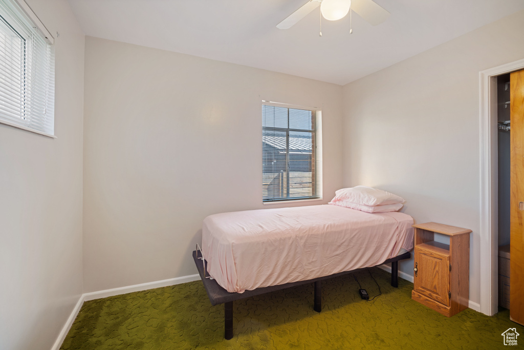 Carpeted bedroom with baseboards and a ceiling fan