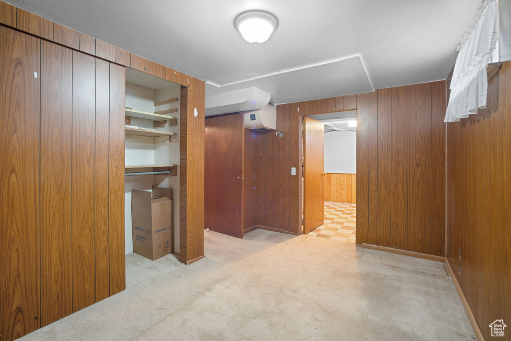 Corridor with wood walls, carpet, and a wall mounted AC