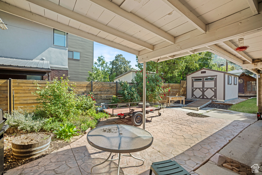 Fenced backyard with a patio and a storage unit