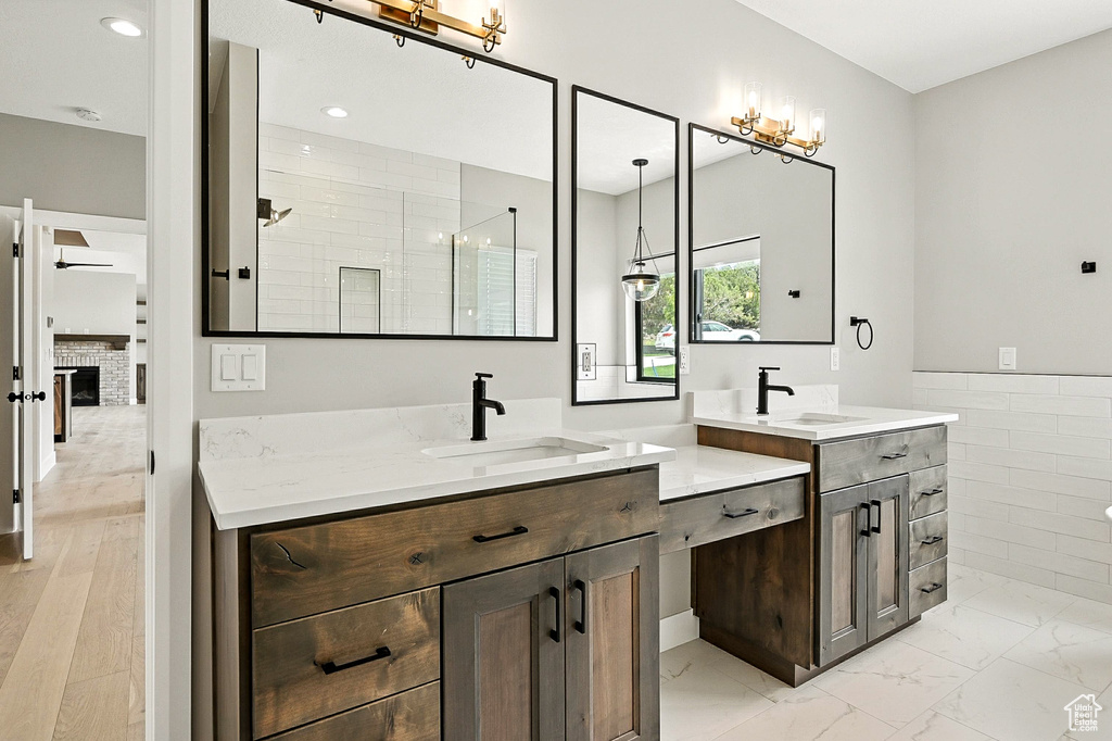 Full bathroom with two vanities, tiled shower, marble finish floors, a chandelier, and recessed lighting
