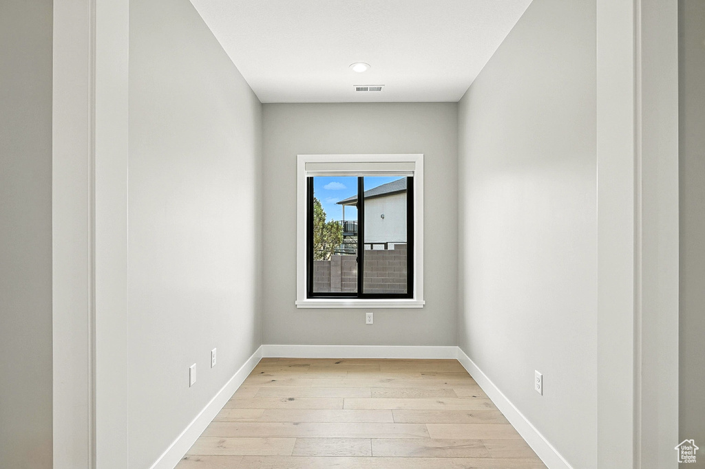 Empty room with light wood finished floors and baseboards