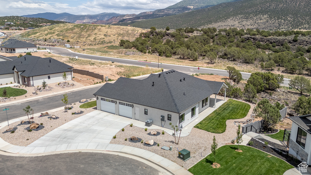 Aerial view of property and surrounding area featuring a mountainous background