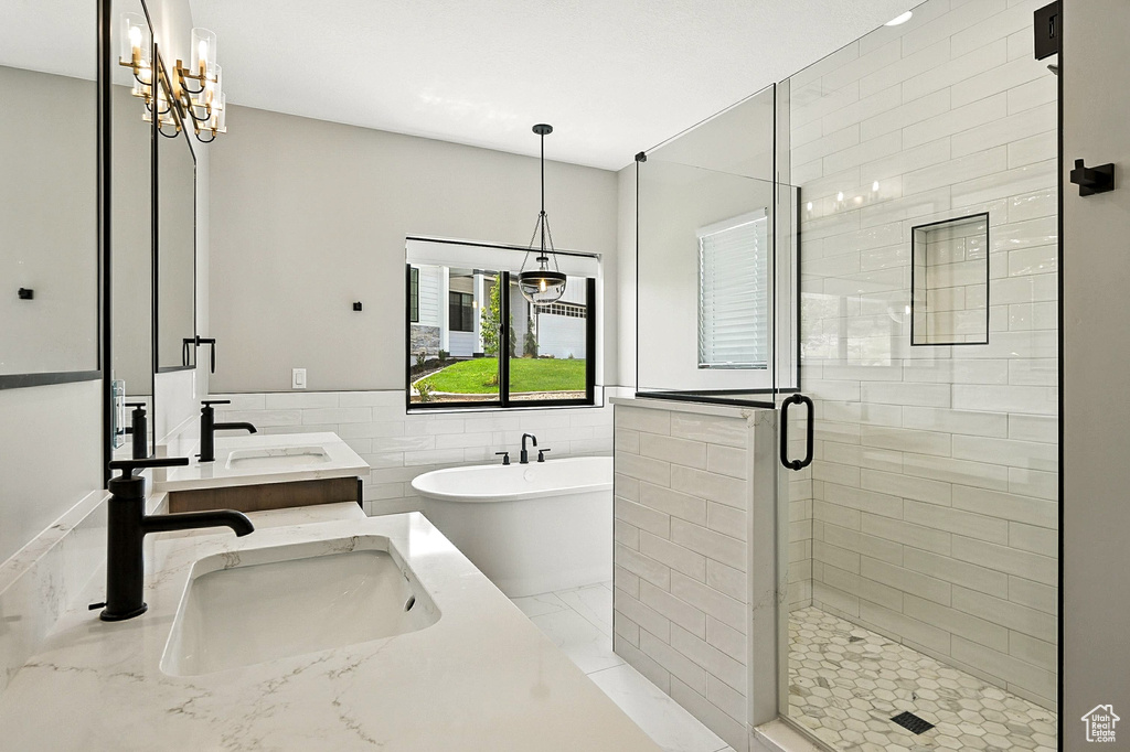 Full bathroom featuring double vanity, a freestanding bath, a shower stall, tile walls, and a wainscoted wall