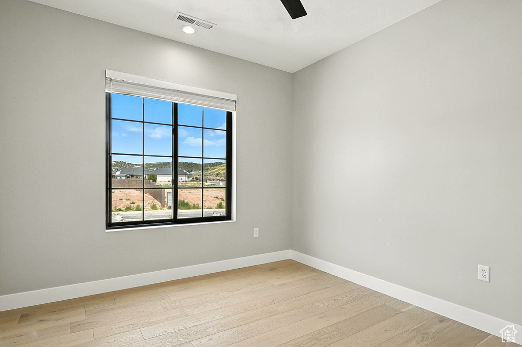 Empty room featuring light wood-type flooring and ceiling fan