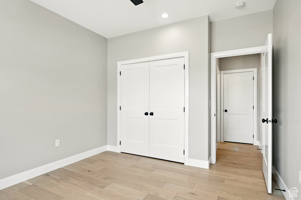 Unfurnished bedroom with light wood-style floors, a closet, and recessed lighting