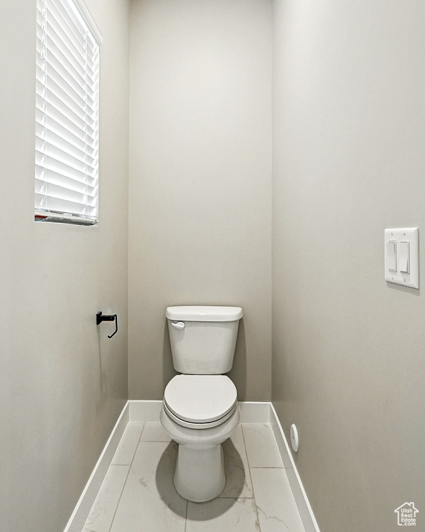 Bathroom with baseboards and marble look tile flooring