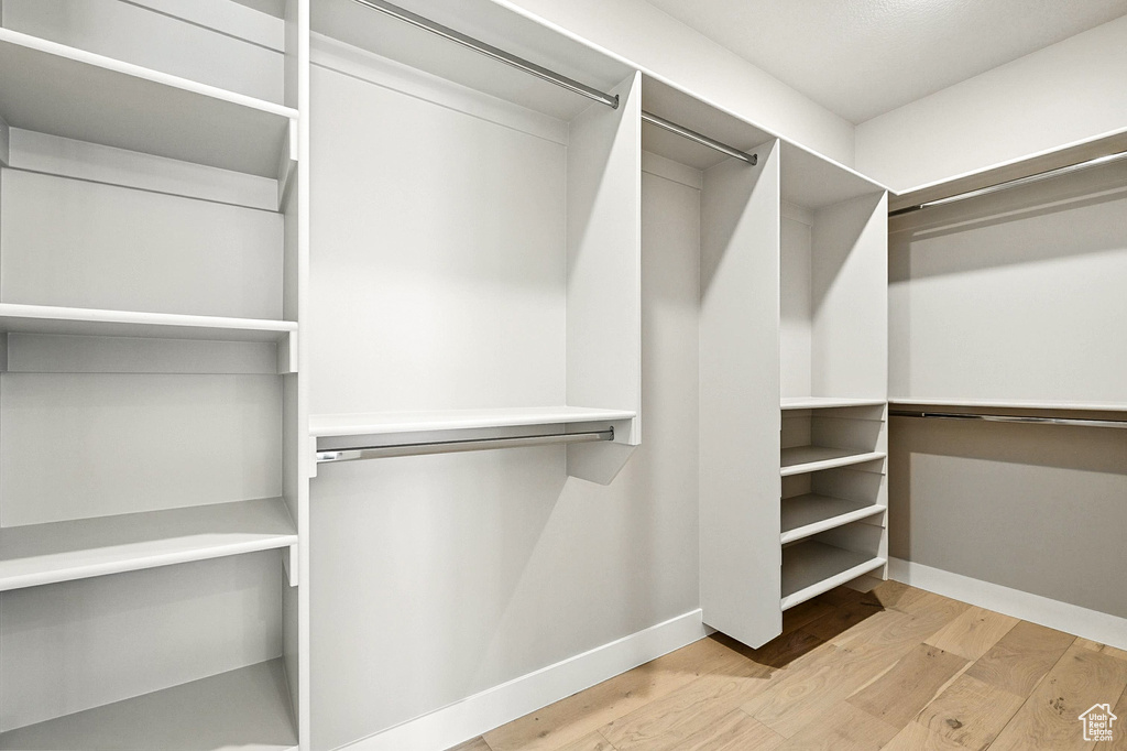Walk in closet with light wood-type flooring