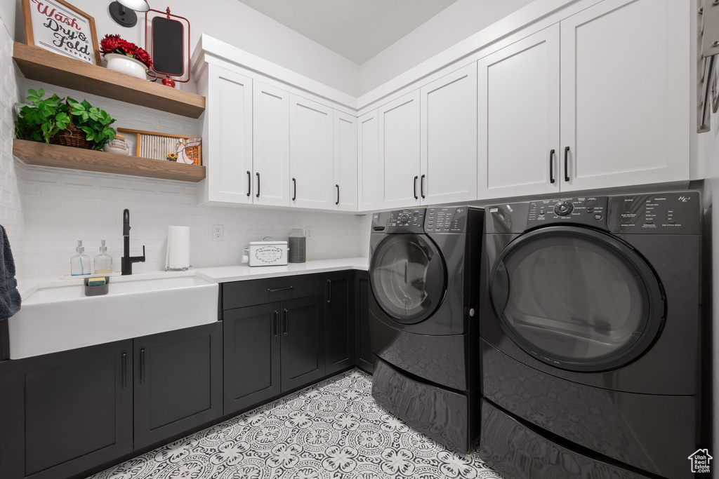 Laundry room with cabinet space, washing machine and dryer, and light tile patterned flooring