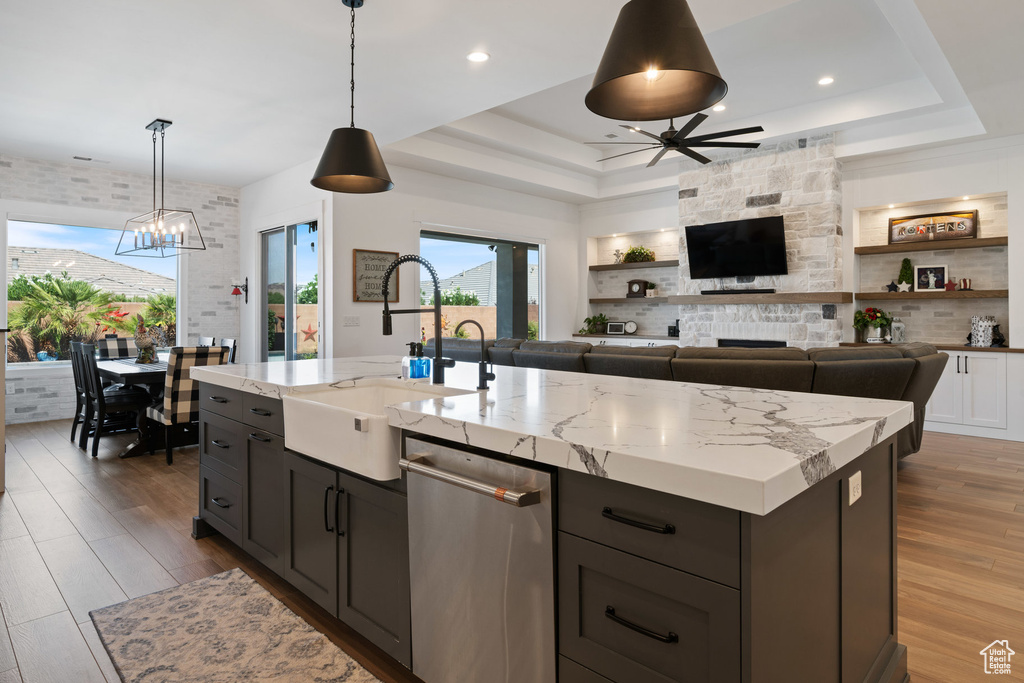 Kitchen featuring dishwasher, a ceiling fan, a tray ceiling, wood finished floors, and recessed lighting