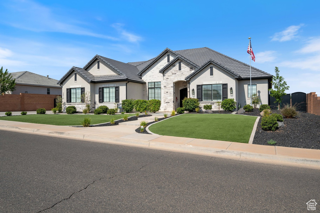 View of front of home featuring stone siding, stucco siding, and a tile roof