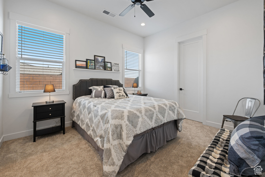 Bedroom featuring light colored carpet, ceiling fan, and recessed lighting