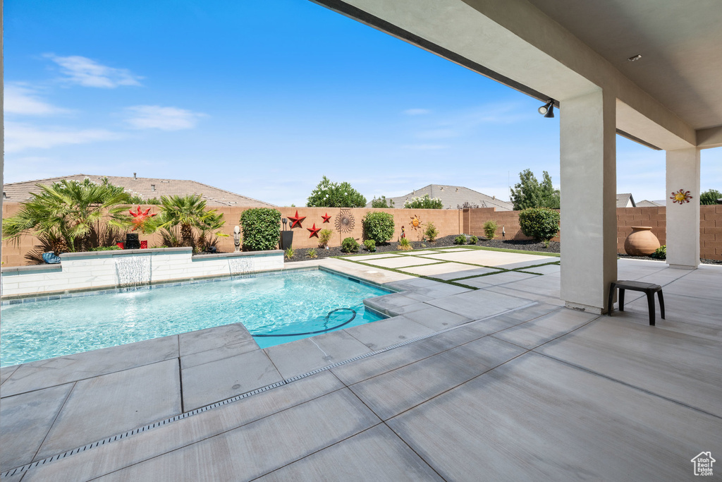 View of swimming pool with a patio and a fenced backyard