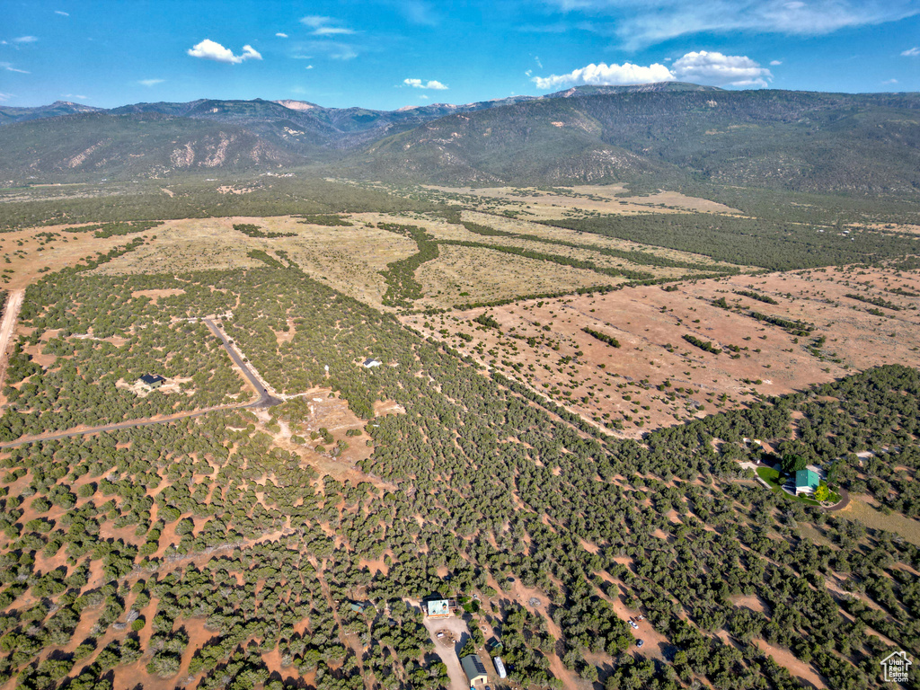 Aerial view of property and surrounding area with a mountainous background and rural landscape