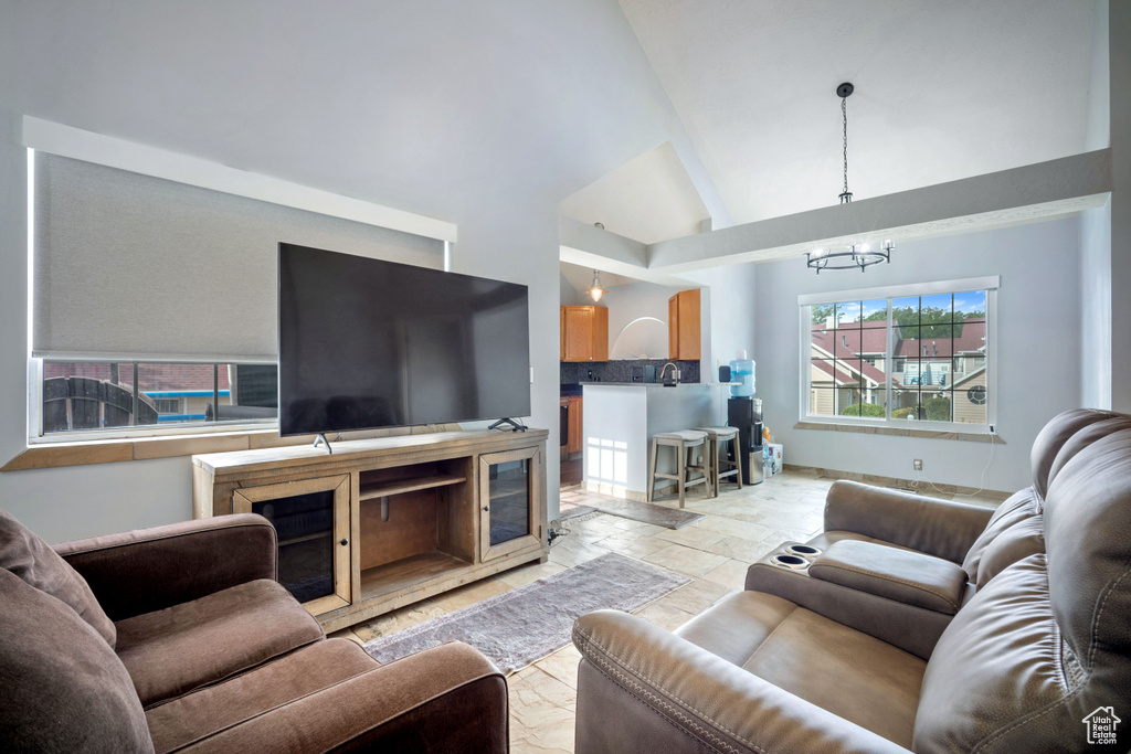 Living area featuring a chandelier and high vaulted ceiling