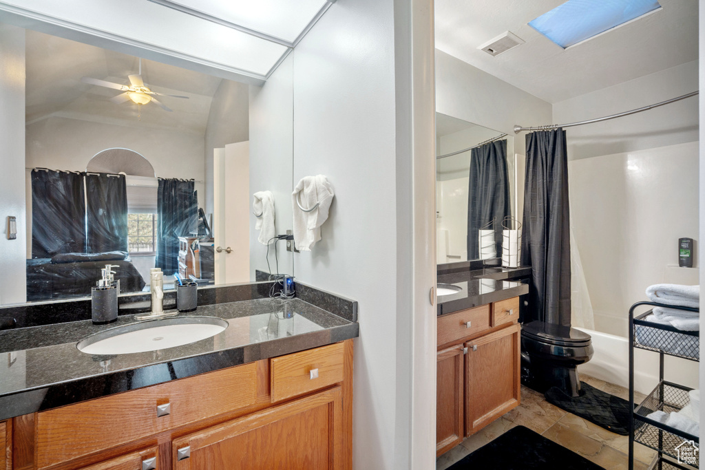 Full bath featuring shower / tub combo with curtain, vanity, a ceiling fan, and vaulted ceiling