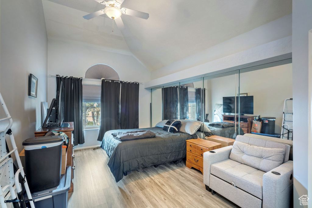 Bedroom featuring light wood finished floors, high vaulted ceiling, and a ceiling fan