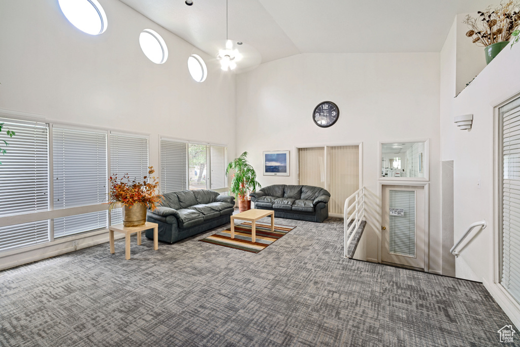 Carpeted living room with high vaulted ceiling