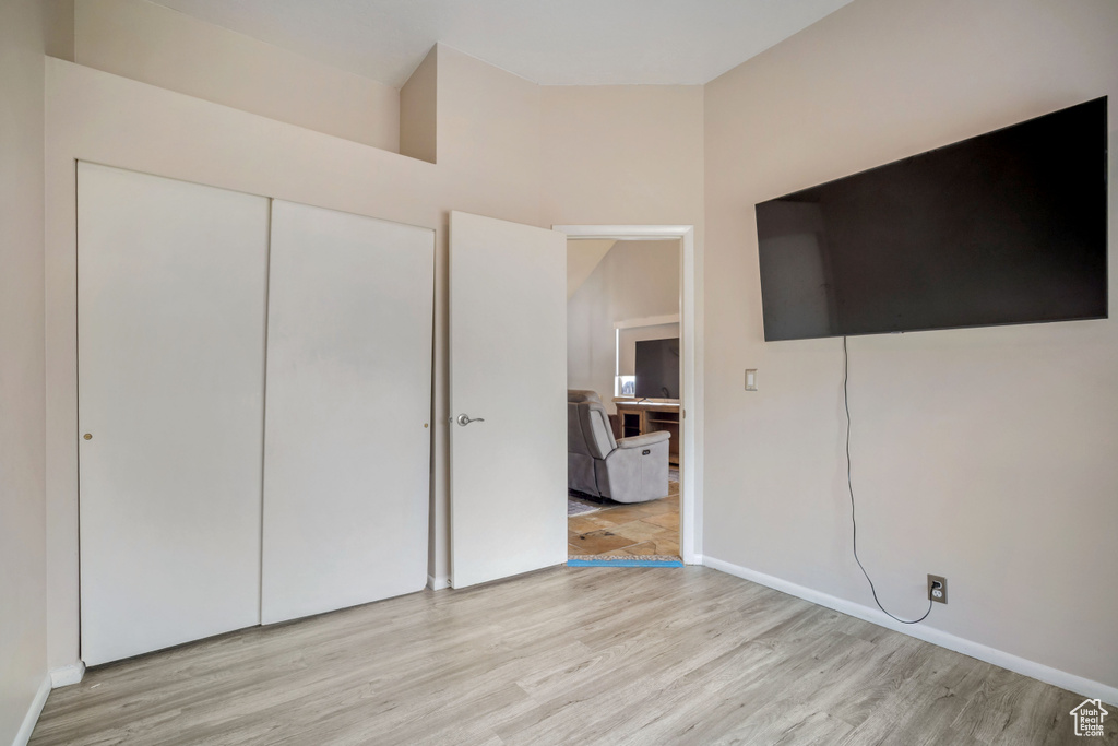 Unfurnished bedroom with wood finished floors and a closet