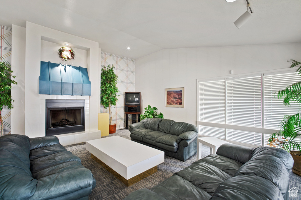 Living area featuring vaulted ceiling and a fireplace