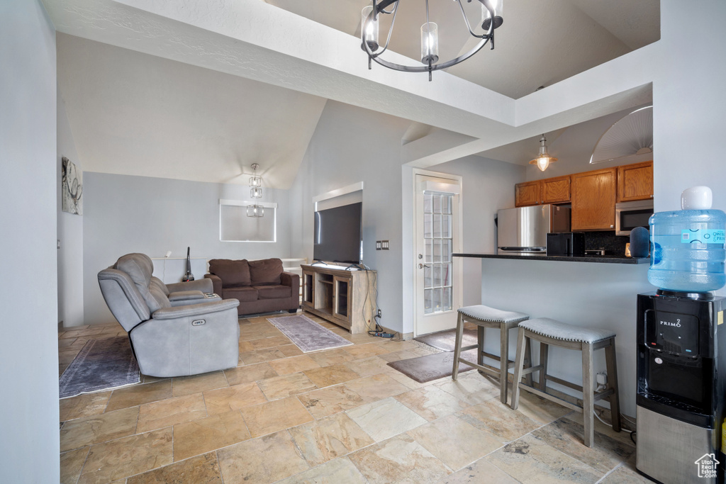 Living room featuring stone tile flooring and a chandelier
