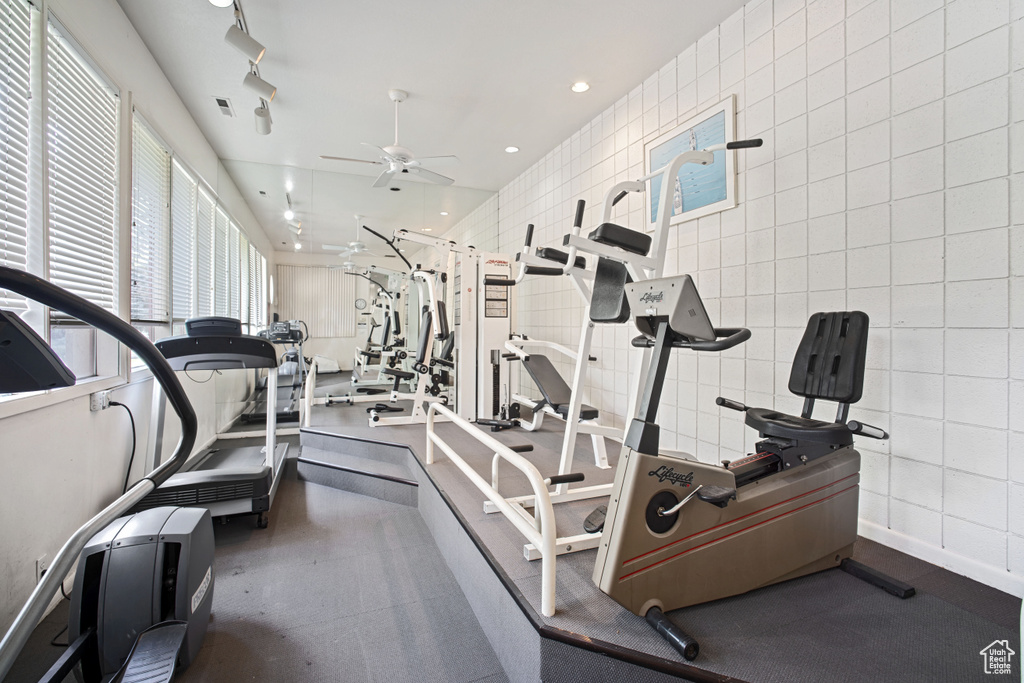 Workout area featuring a ceiling fan, tile walls, and recessed lighting