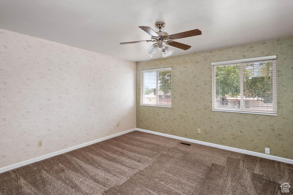 Spare room featuring carpet floors and ceiling fan