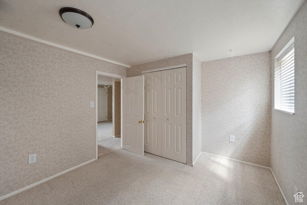 Unfurnished bedroom with a closet and carpet flooring