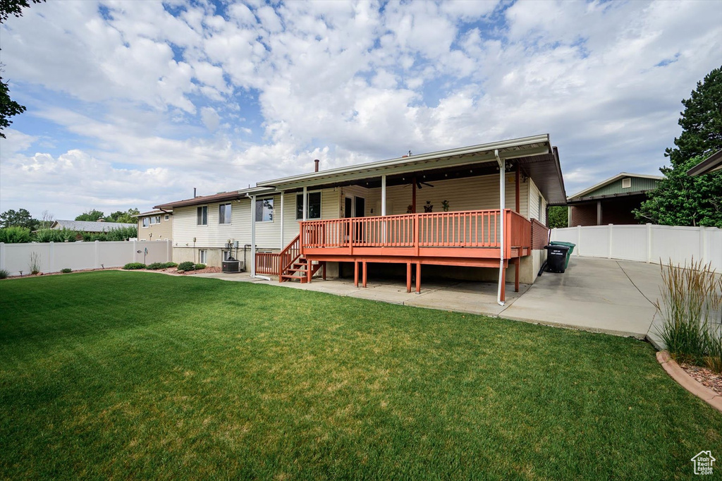 Back of property with a fenced backyard, a deck, ceiling fan, and a patio