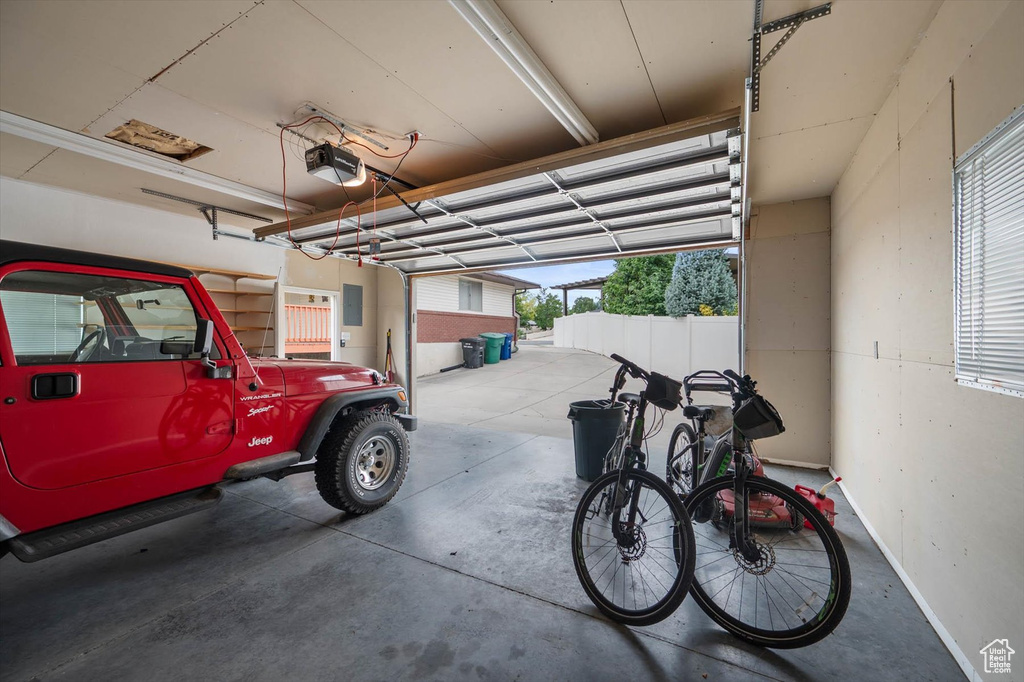 Garage featuring a garage door opener and electric panel