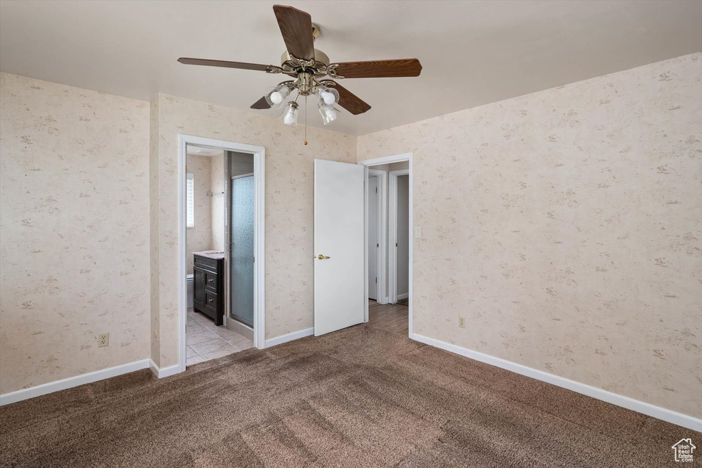 Empty room featuring light colored carpet and ceiling fan