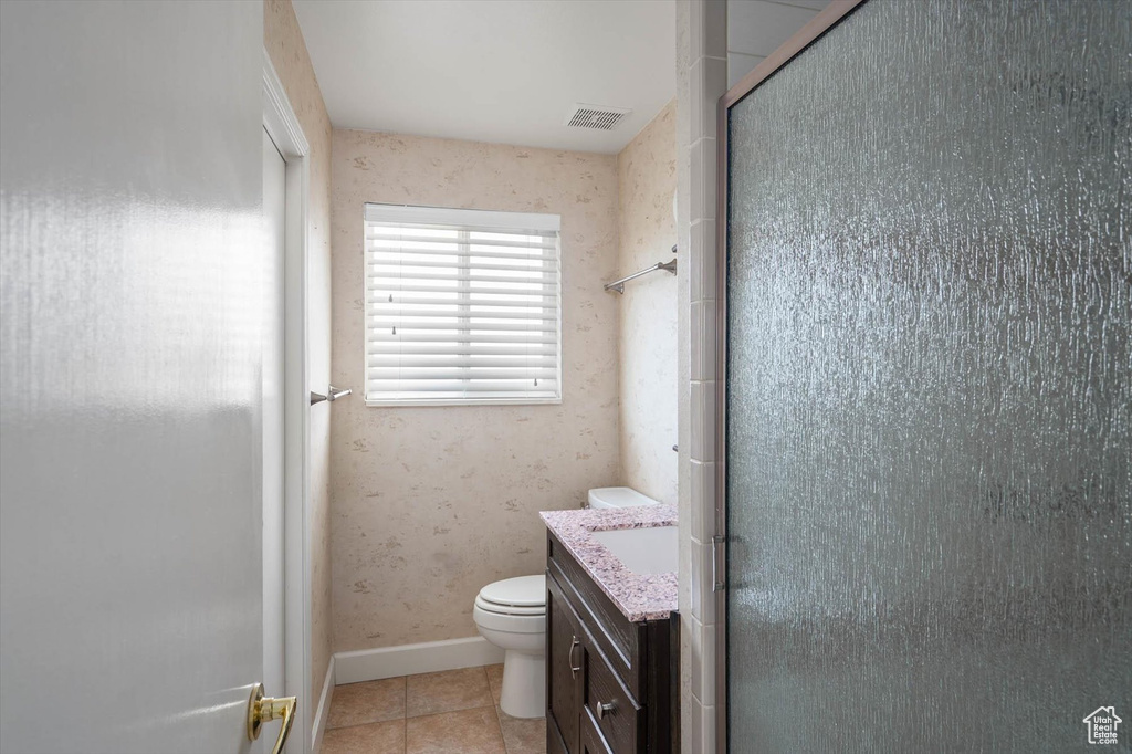 Bathroom with vanity, a stall shower, and tile patterned flooring