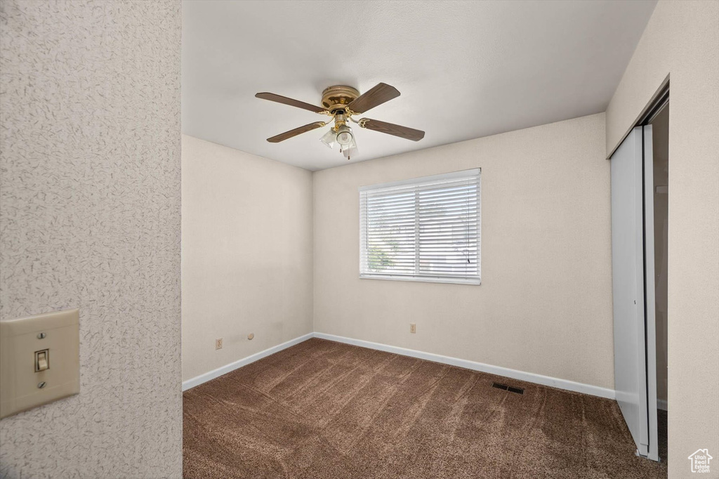 Unfurnished bedroom featuring carpet floors, a closet, and ceiling fan