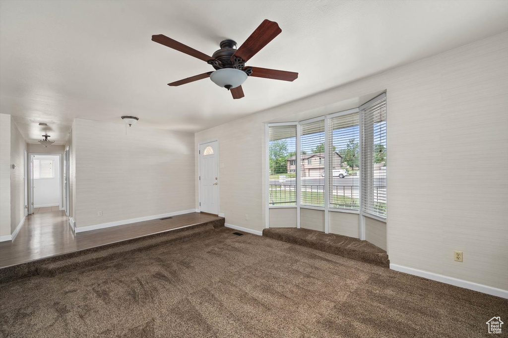 Empty room featuring carpet floors and ceiling fan