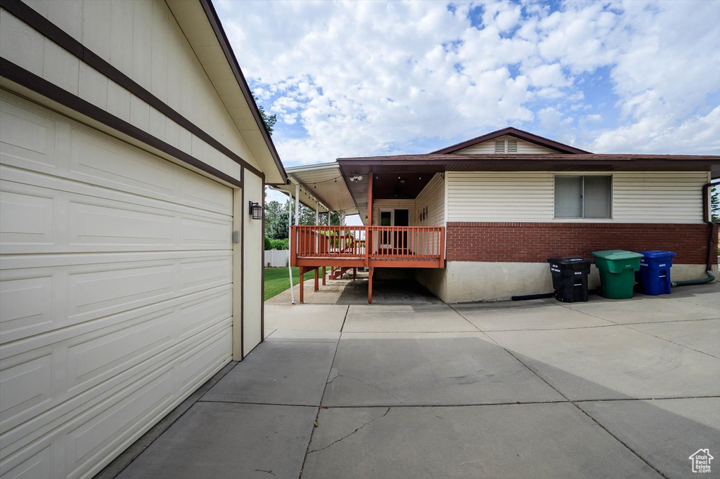 View of home\'s exterior with a garage, brick siding, and a deck