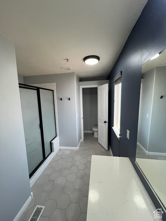 Bathroom with a stall shower and tile patterned floors