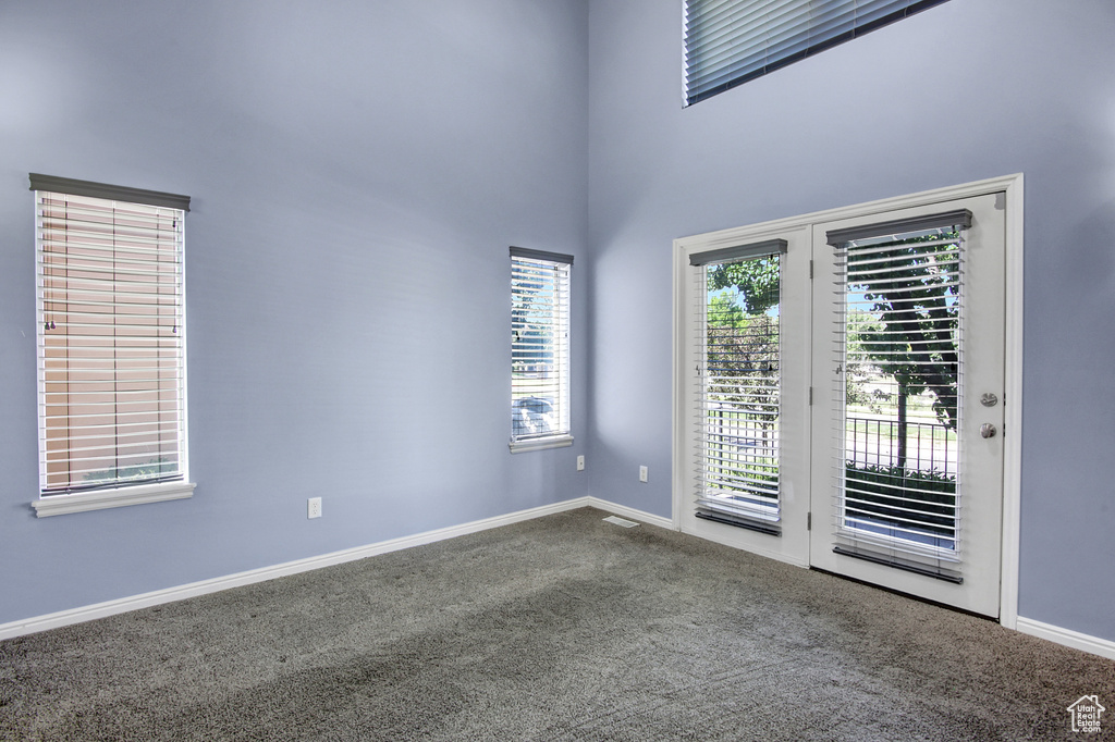 Spare room featuring carpet and a high ceiling