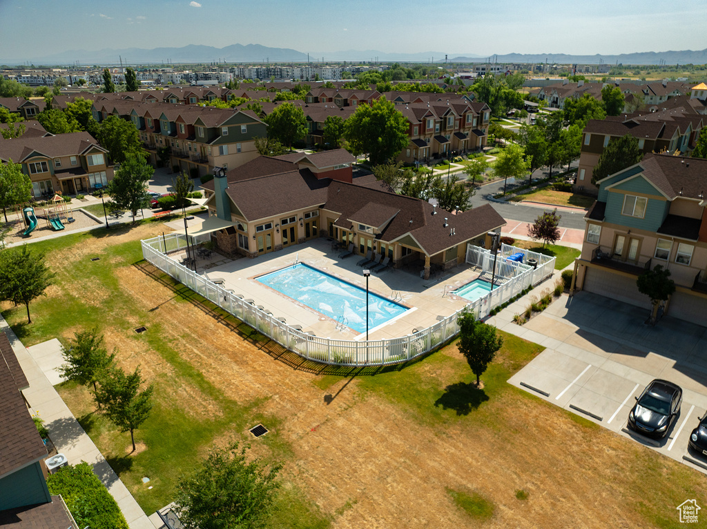 Aerial perspective of suburban area featuring a pool and mountains
