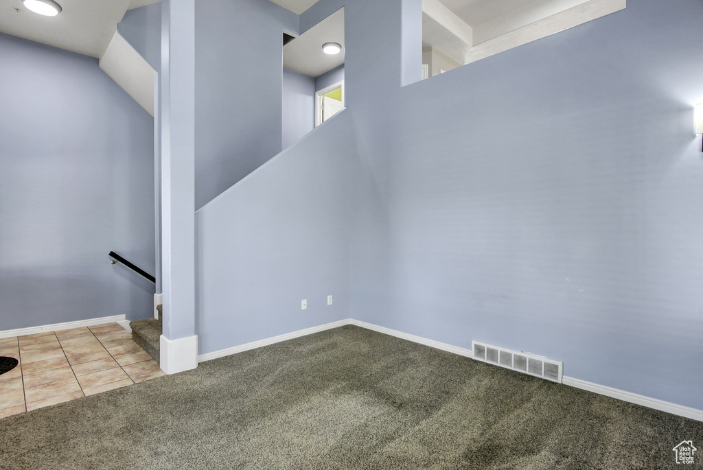 Staircase featuring carpet flooring and tile patterned floors