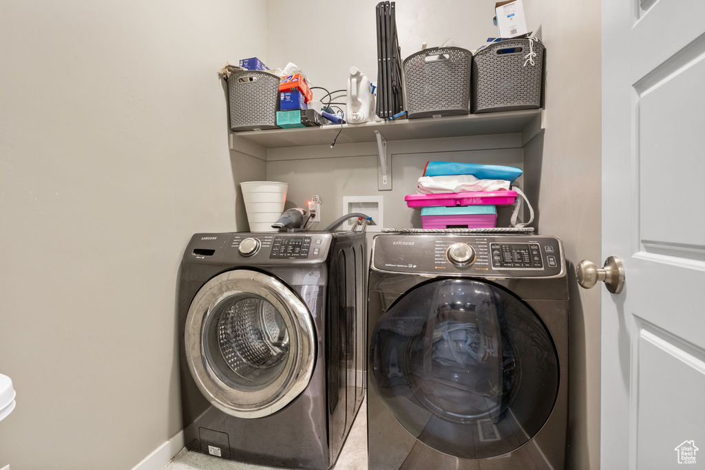 Laundry room featuring washer and clothes dryer and baseboards