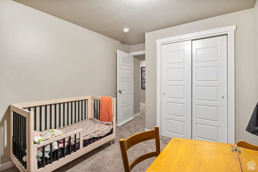 Carpeted bedroom featuring a closet and baseboards