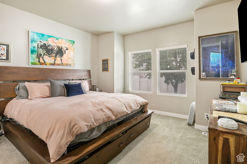 Bedroom featuring light carpet and baseboards