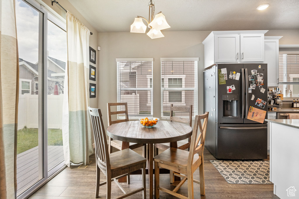 Dining area featuring a chandelier, healthy amount of natural light, wood finished floors, and recessed lighting